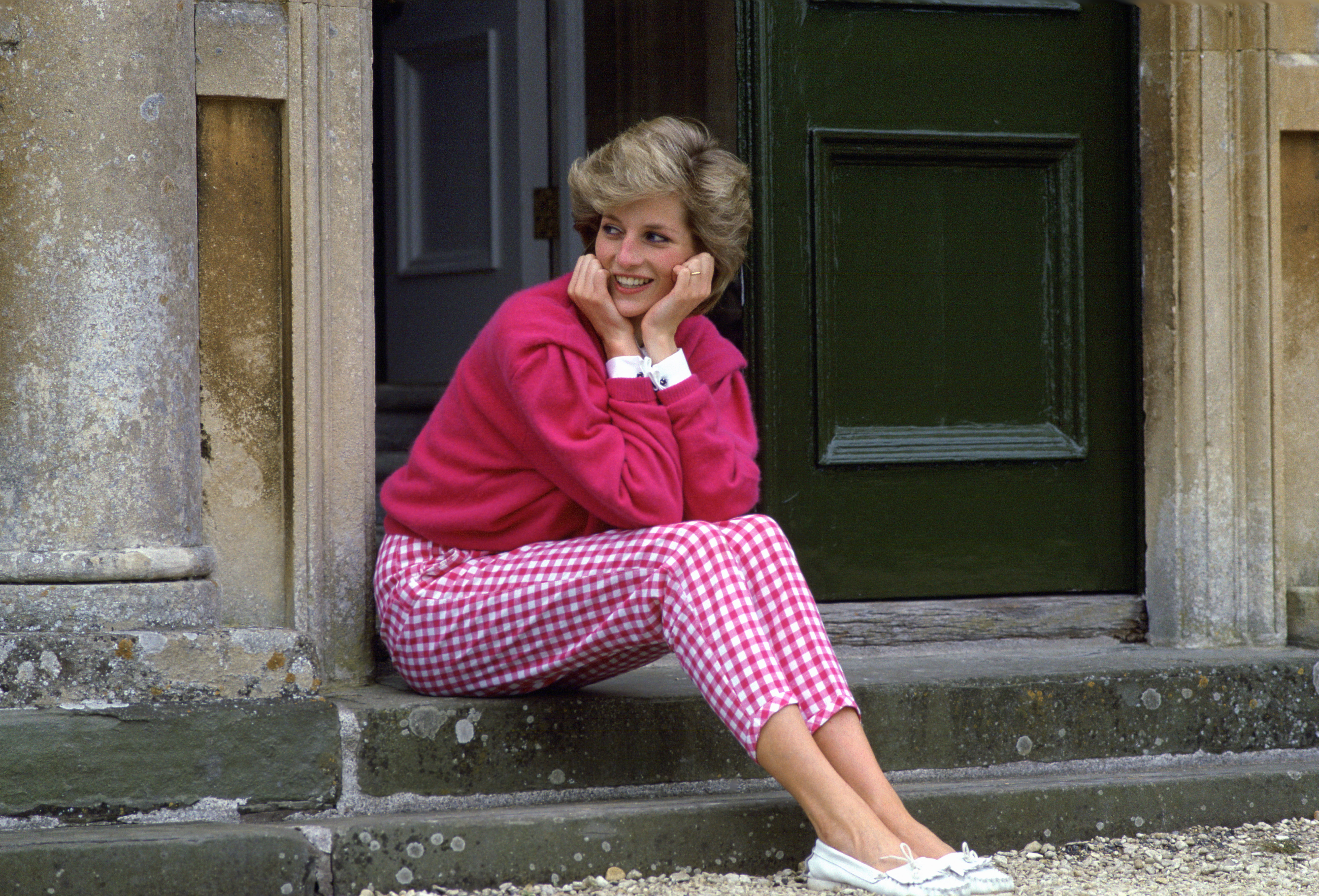 Diana, Princess Of Wales, Sitting On The Steps Outside Her Country Home, Highgrove. The Princess Is Casually Dressed In Pink Gingham Trousers With A Matching Pink Jumper. (Photo by Tim Graham Photo Library via Getty Images)