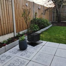 grey patio with wooden wall and potted plants