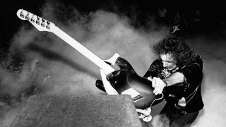Ritchie Blackmore attacks his amp with his guitar onstage at the 1974 California Jam