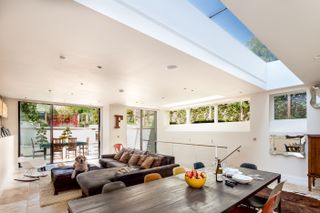 kitchen diner and living space in a basement extension to a Victorian home with a golden retriever lying on the grey sofa