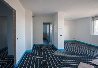Underfloor heating pipes in a large room on plastic backing boards