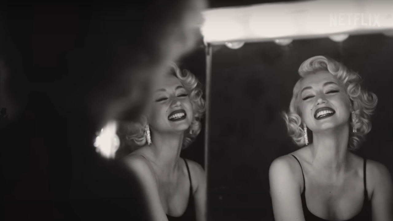 Ana de Armas smiling in the mirror as Marilyn Monroe in Blonde.