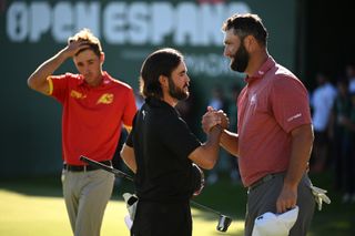 Angel Hidalgo shakes hands with Jon Rahm on the 18th green