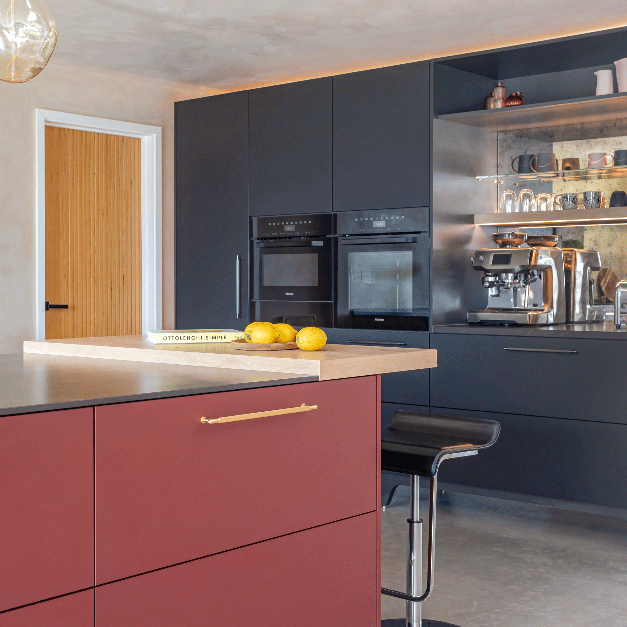 modern kitchen with a burgundy kitchen island and dark blue cabinets