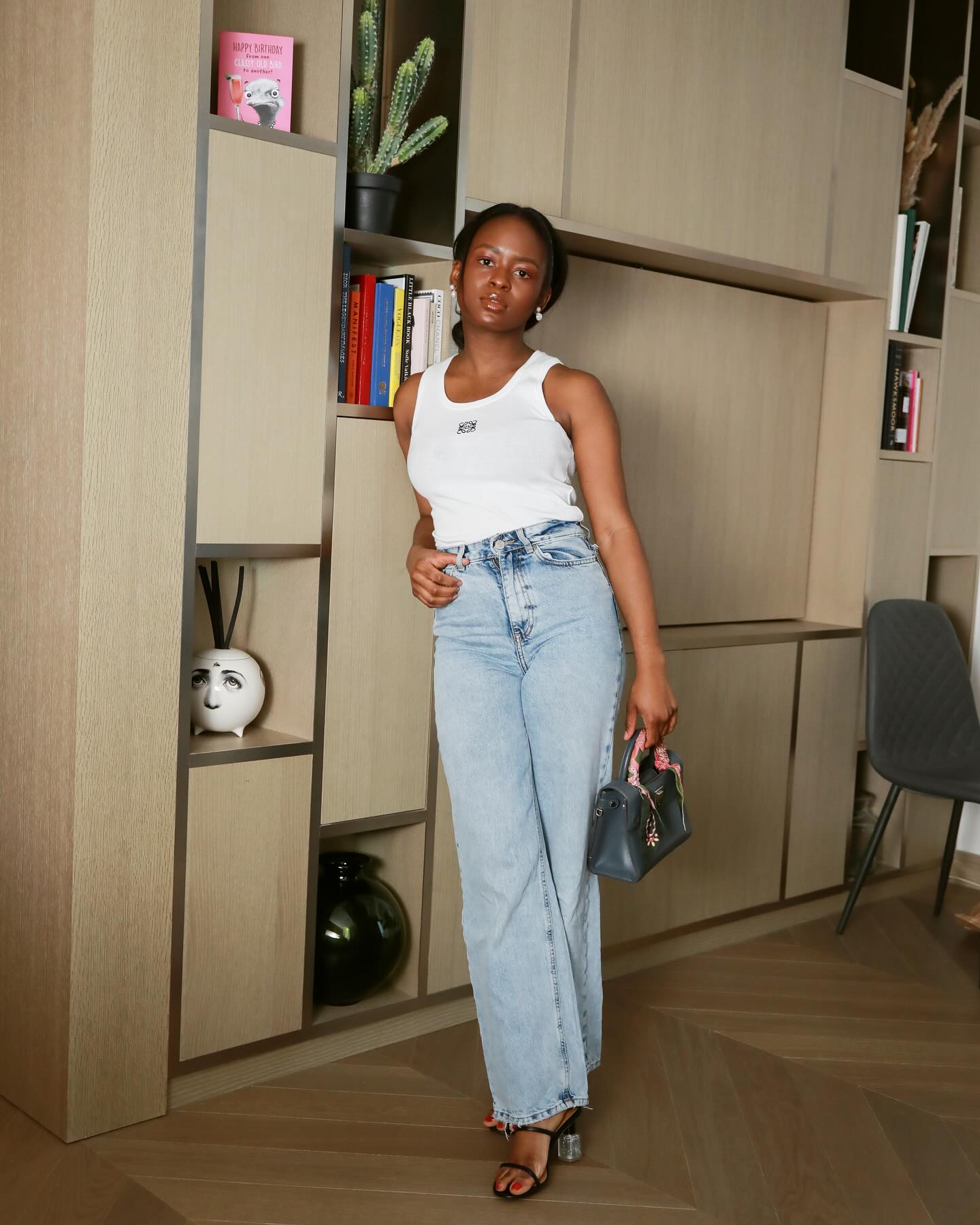 90s capsule wardrobe: @eniswardrobe wears a white tank top with lightwash jeans