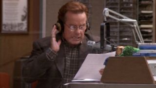 Phil Hartman sitting in the broadcast booth in NewsRadio.
