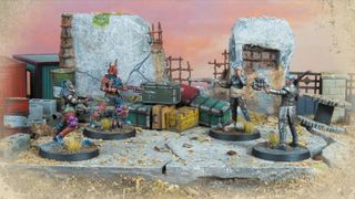 Models from Fallout Factions face off against one another on a battlefield of ruined buildings