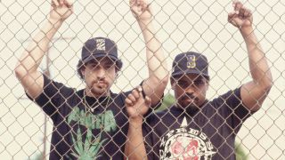 Cypress Hill rappers B Real and Sen Dog behind a chain link fence