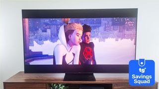 The TCL QM7K displaying a scene from "Spider-Man: Across the Spider-Verse" alongside a blue-colored badge that reads: "TG Savings Squad"