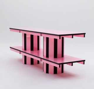 Two cylinders in pink and black stripe positioned next to each other carbed into two pink rectangles sitting parallel on top of each other.