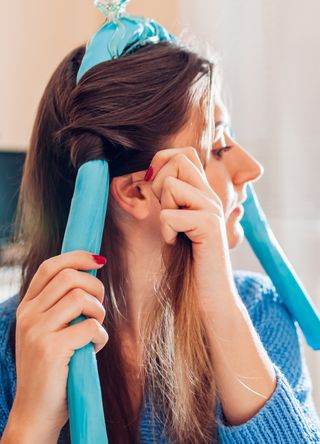 Woman using heatless curlers