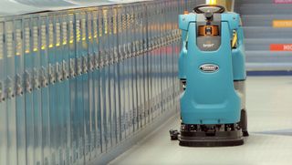 A robot cleaner cleans a school near a row of lockers.