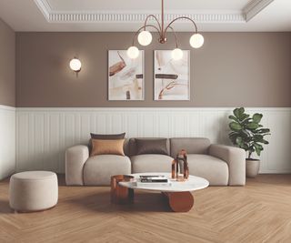 living room with walls painted in soft shade of brown on top half, lower sections covered in white traditional panelling, wooden floor, beige sofa, footstool and white and dark wood organic shaped coffee table