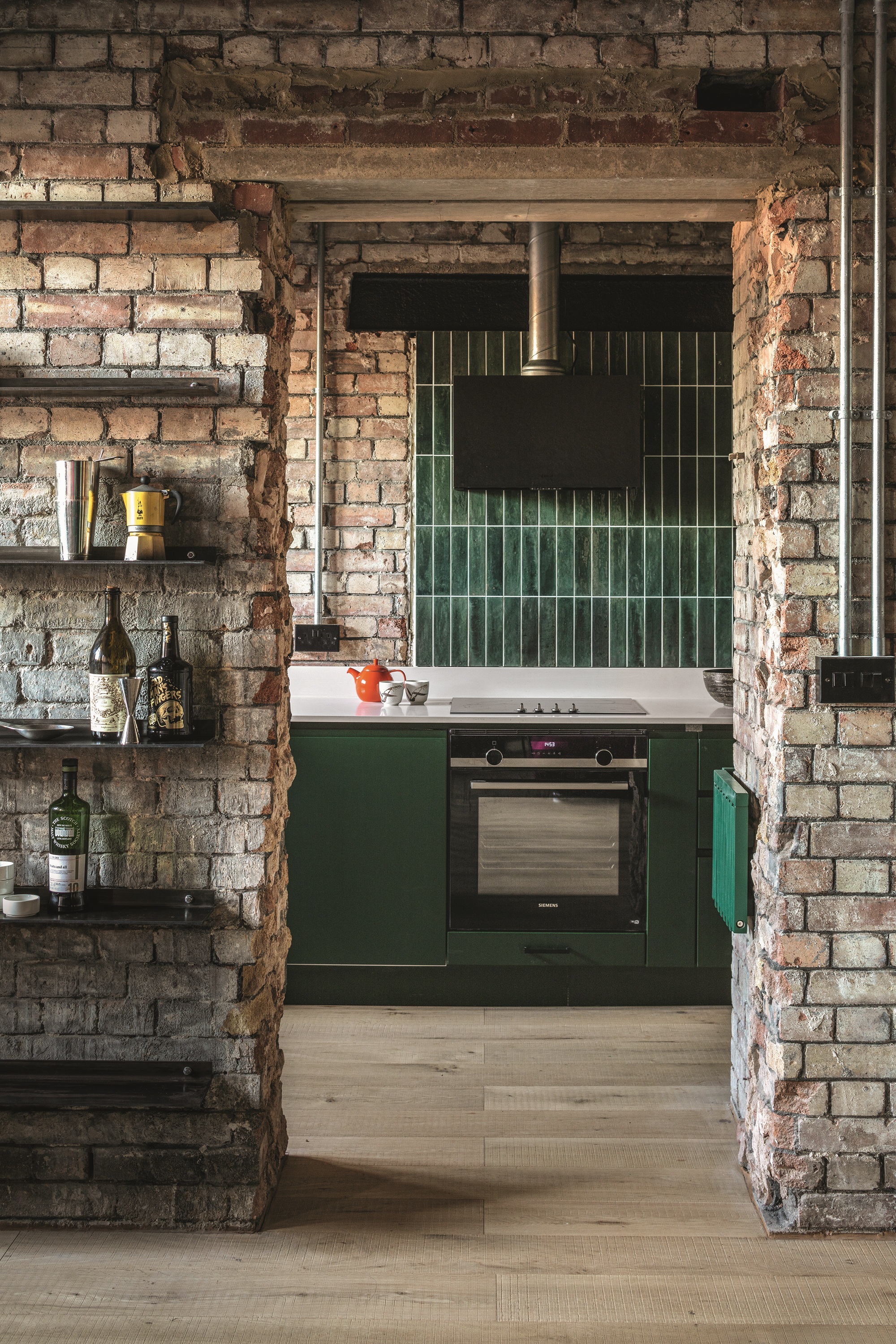 Black office chair by Herman Miller. Band-sawn oak flooring. Custom cabinetry designed by Inter Urban Studios, painted moss green (Ral).
