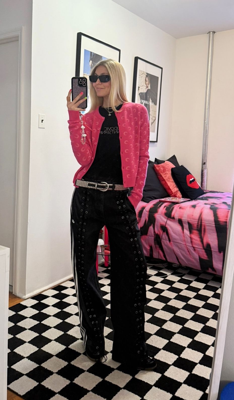 Jessica Minkoff posing in mirror wearing sunglasses, pink jacket