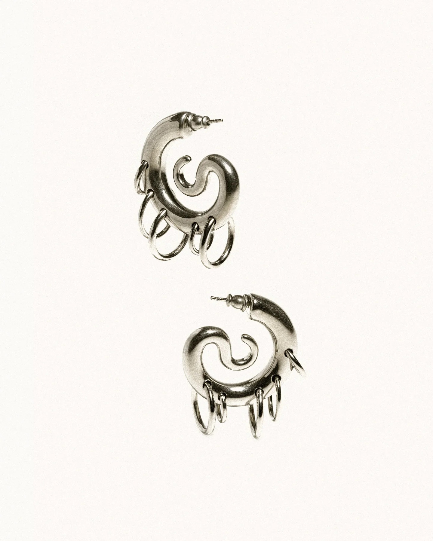 Whimsical silver hoop earrings.