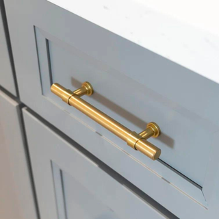 A blue cabinet with a long gold door pull