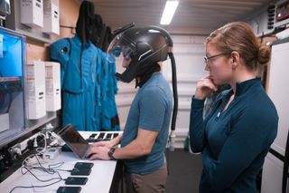 Officer Dr. Lindsey Kishline performing tests on Officer Al Moulah, as part of her research study on augmented reality for spacesuit helmets.