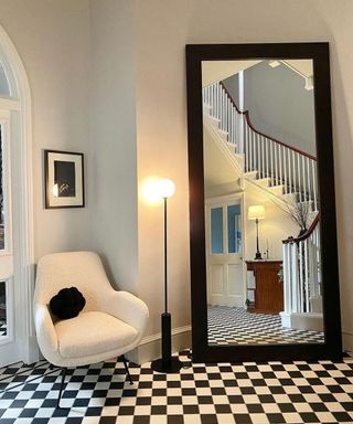 Long black hallway mirror with boucle Made.com chair and monochrome checked floor