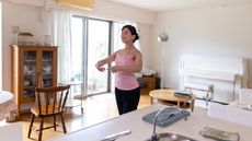 Woman at home standing in ballet stance with her arms in first position