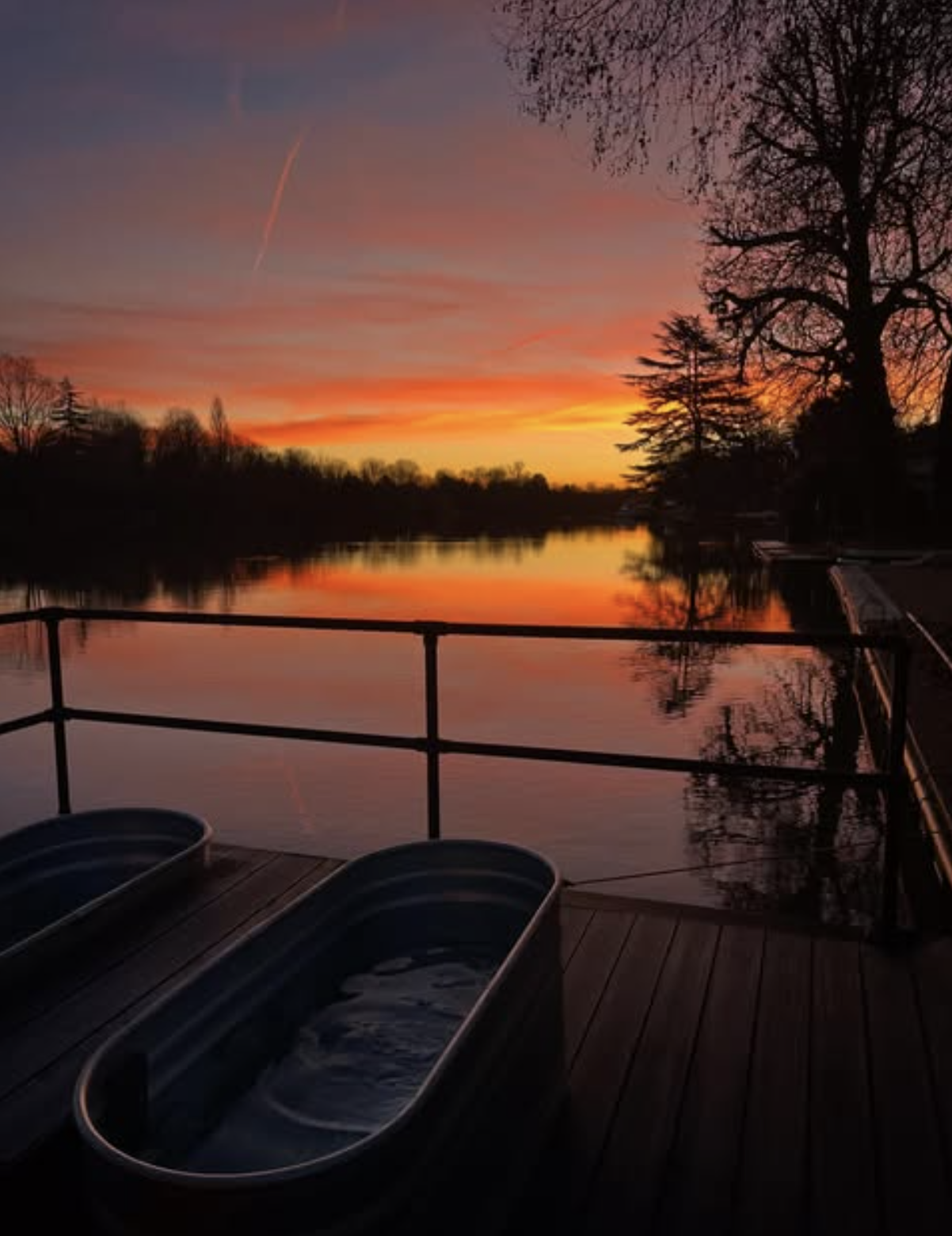 an image of the ice baths on the floating saunas which overlook the Thames whilst there is a winter sunset