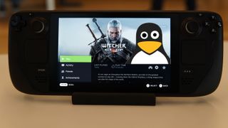 Linux Penguin on the screen of a Steam Deck with Geralt from the Witcher 3. 