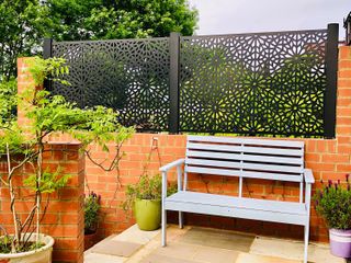garden privacy ideas: screen with envy decorative screen on brick wall with bench