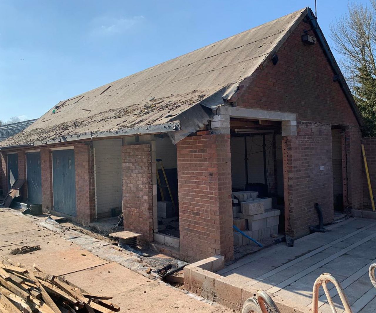 before and after images of garage block converted into an extended annexe with larch gladding and pitched roof
