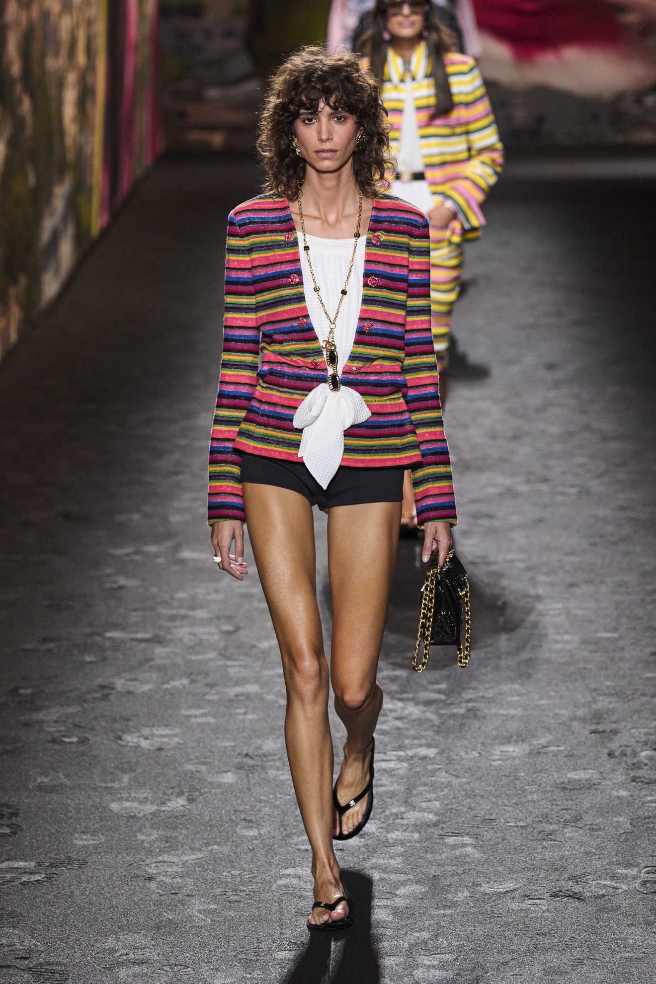 a Chanel model walks the spring 2024 runway wearing flip-flops