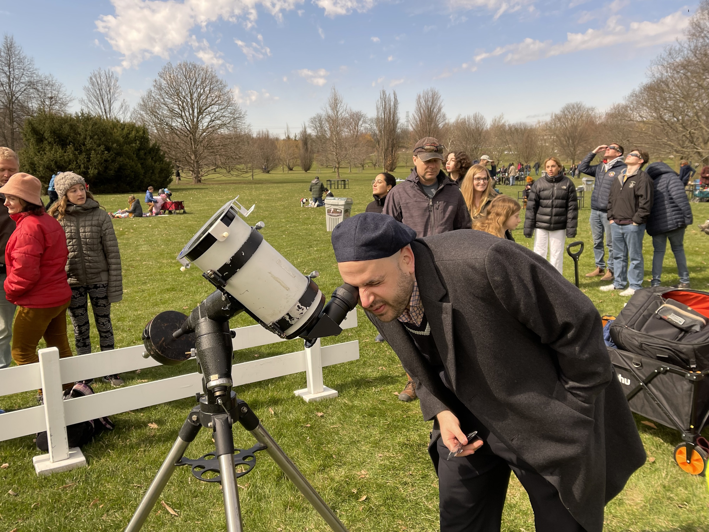 A crowd gathers to look through a telescope with a solar filter at Canada's Royal Botanical Gardens