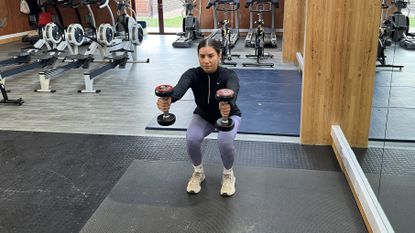 Fitness writer Daniella Gray performing a squat with front raise