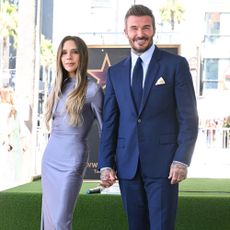 Victoria Beckham joins David Beckham as he receives a star on the Hollywood Walk of Fame, wearing a lilac dress with dark purple heels.