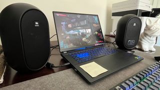 JBL 104-BT speakers next to a gaming laptop on a desk