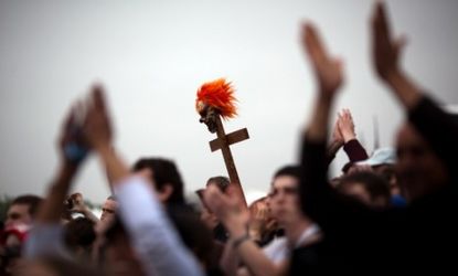 A cross with a clown mask is held during the National Atheist Organization's "Reason Rally" march last month.