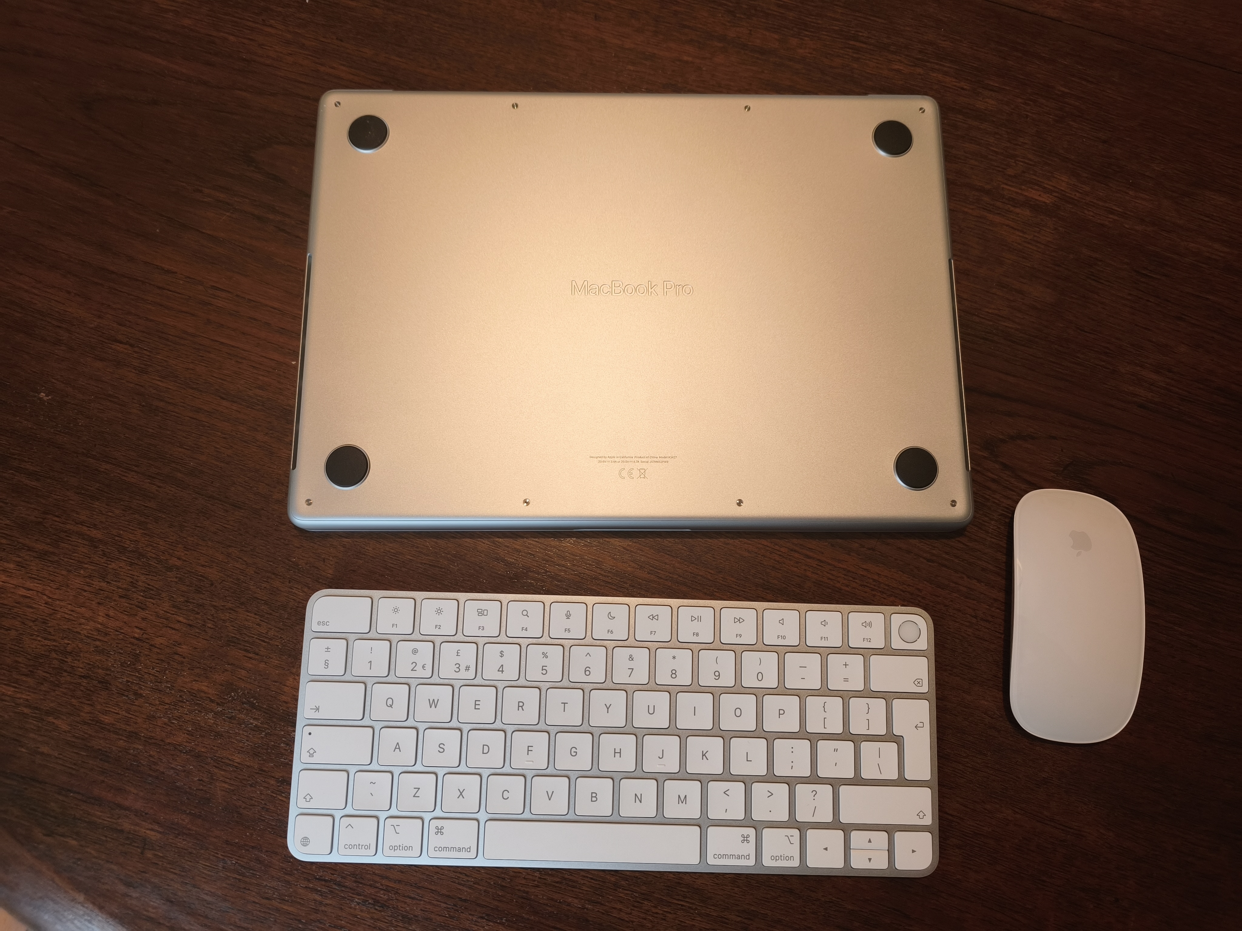 MacBook Pro M5 Max on a dining room table with Apple accessories the Magic Keyboard and Magic Mouse