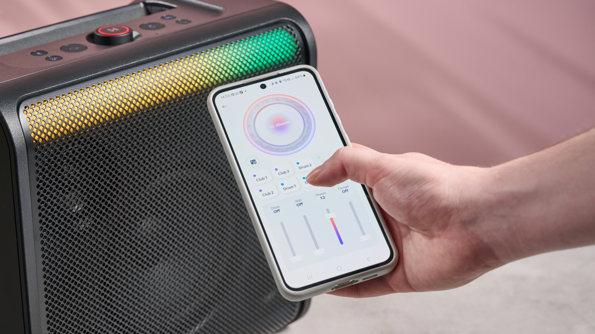 LG xboom Stage 301 with person holding phone next to it with the LG ThinQ app