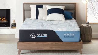 The Serta Arctic Mattress placed on a wooden bed frame in a white bedroom