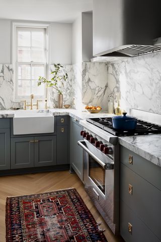 small kitchen with blue cabinets and a rug