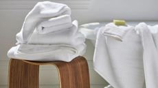 Brooklinen Super-Plush Bath Towels draped over the side of a bath and across a table.