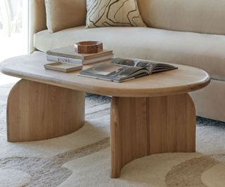 ada oval coffee table on a cream rug in front of a cream couch
