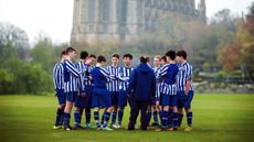 A group of boys on a rugby field at Lansing College