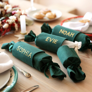 Three green Christmas crackers with personalised names