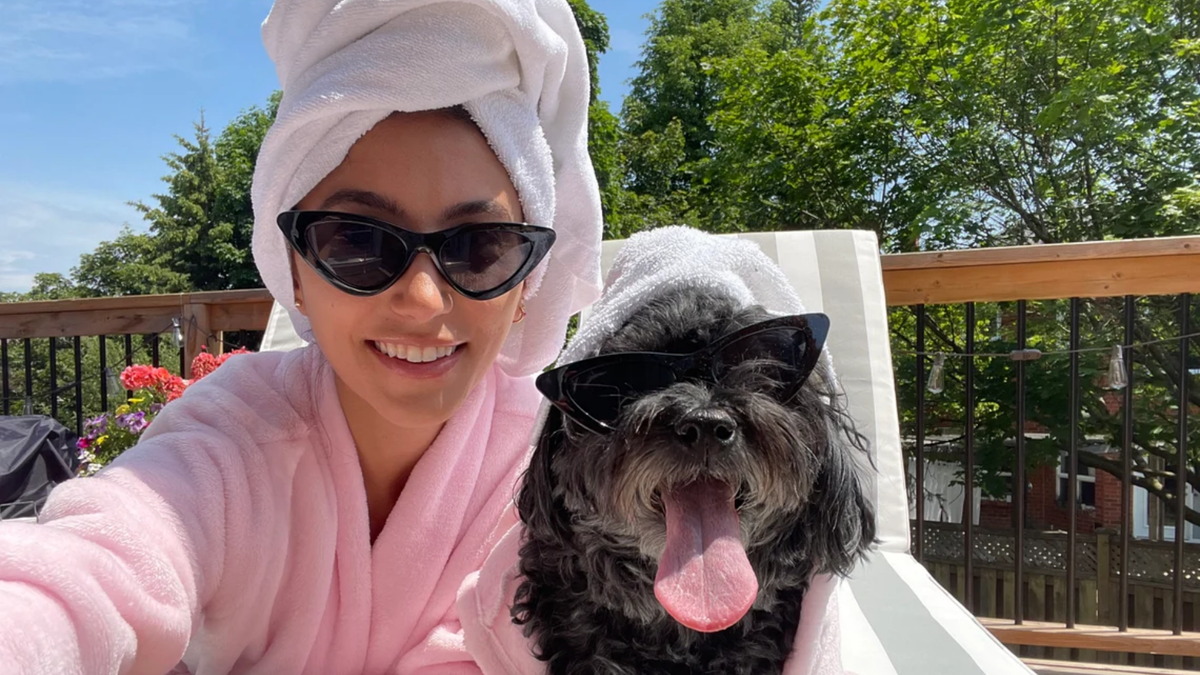 Woman and dog wearing matching robes, sunglasses and towels wrapped on their heads