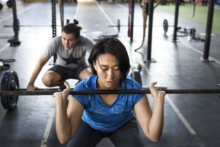 Woman and man weight lifting