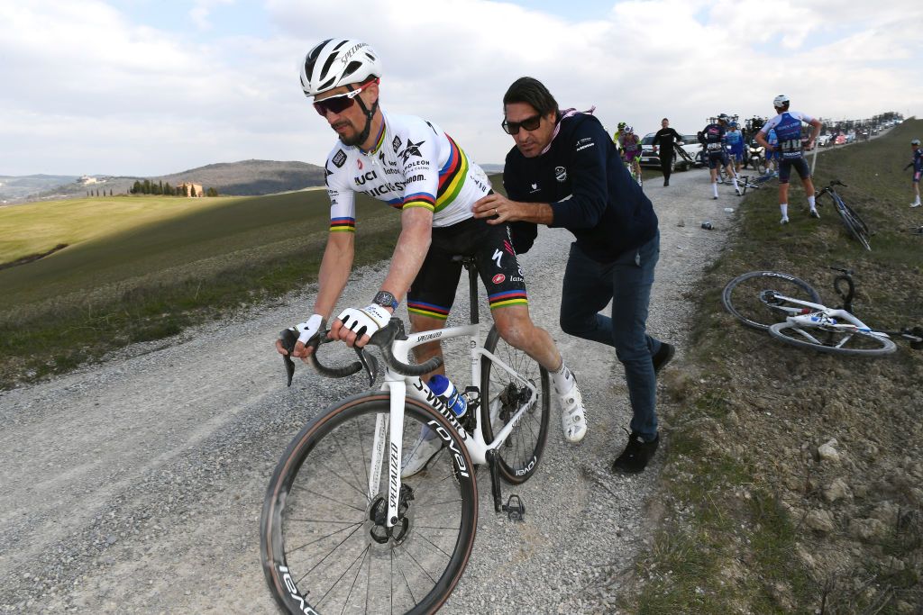 SIENA ITALY MARCH 05 Julian Alaphilippe of France and Team QuickStep Alpha Vinyl help by Davide Bramati Sports Director after being involved in a crash during the Eroica 16th Strade Bianche 2022 Mens Elite a 184km one day race from Siena to Siena Piazza del Campo 321m StradeBianche WorldTour on March 05 2022 in Siena Italy Photo by Tim de WaeleGetty Images
