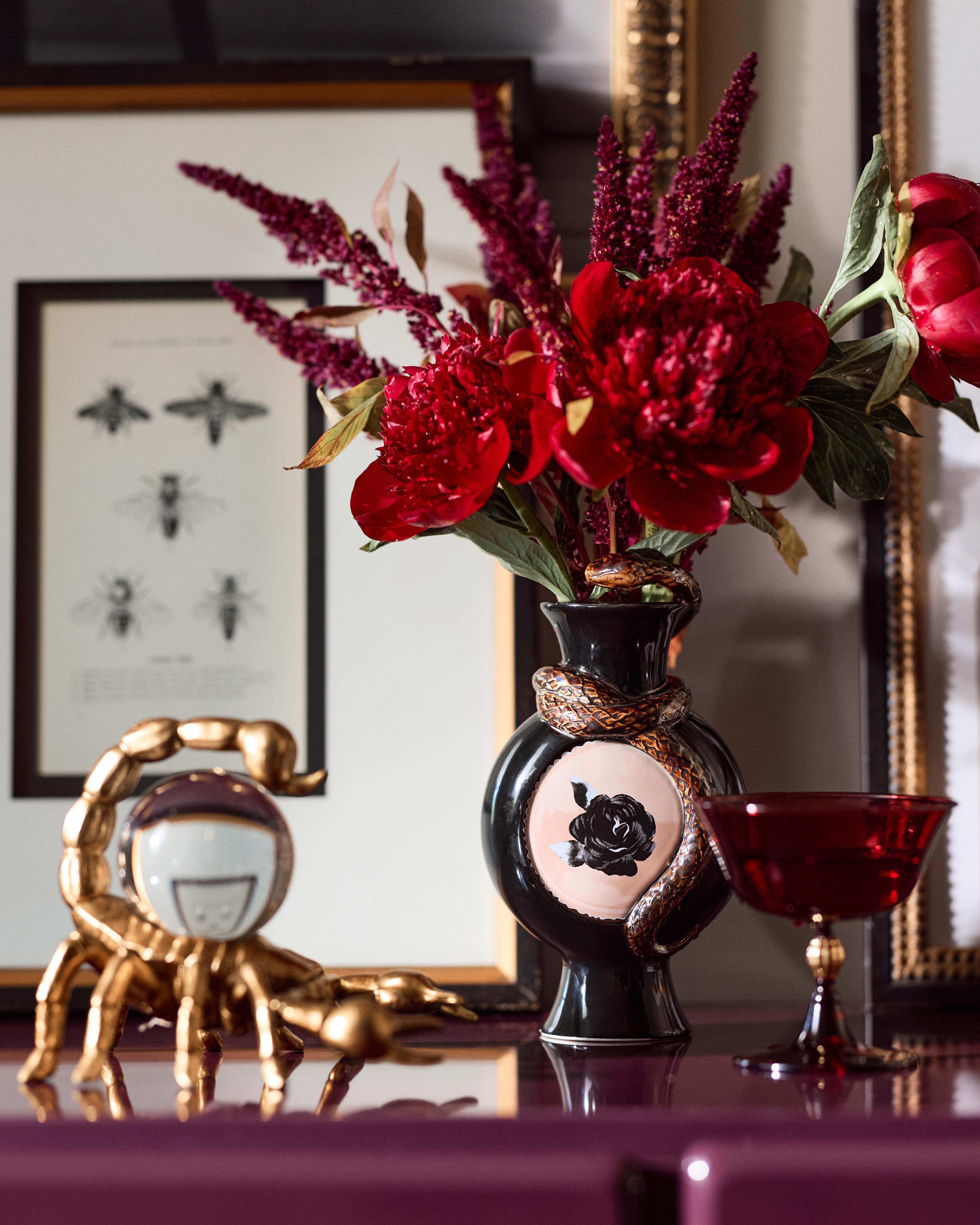 Anthropologie x Catherine Martin Halloween collection brass scorpion, chalace, and snake-accented vase with flowers