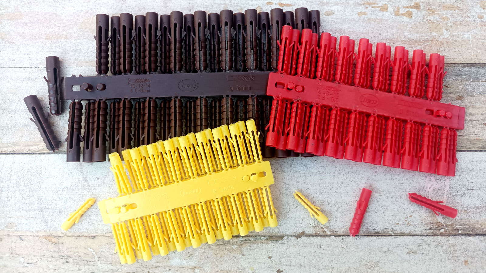 Brown, red and yellow Rawl plugs on white washed wood