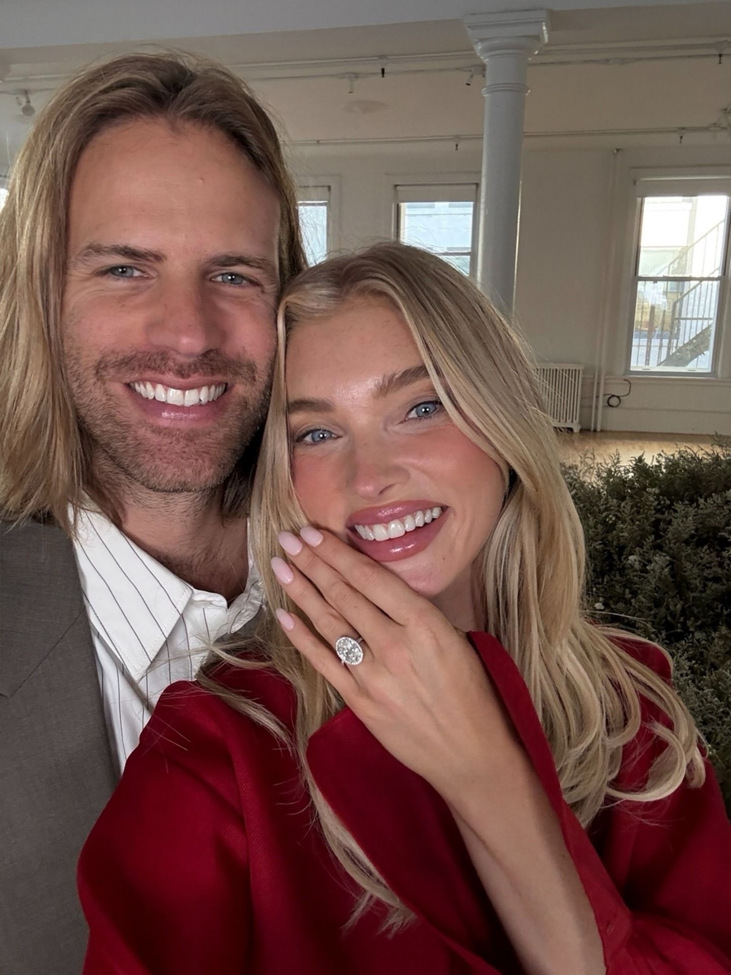 A photo of Elsa Hosk and Tom Daly, with Elsa holding up her hand to show her engagement ring and sheer milky pink nails