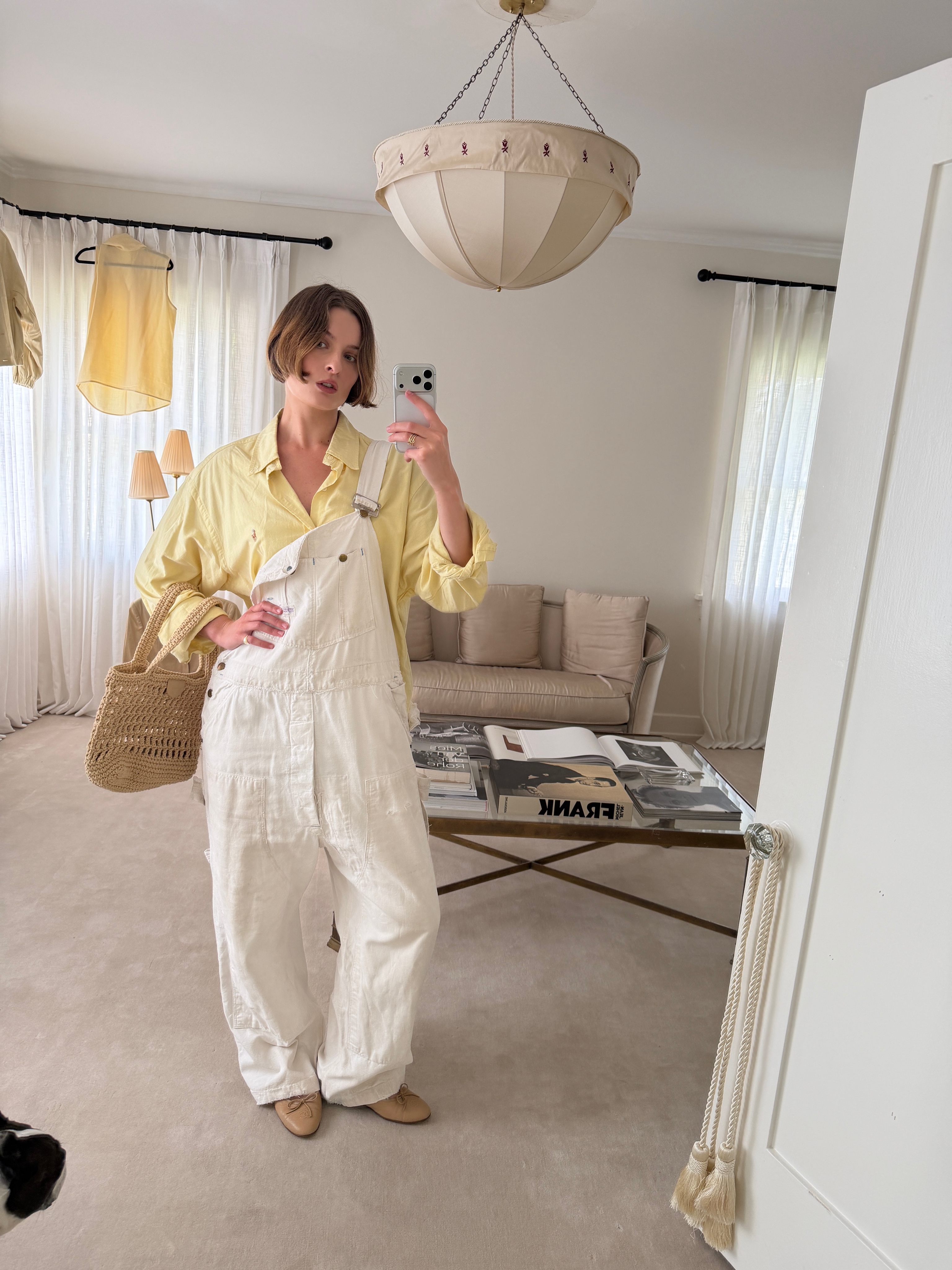 Christie Tyler pairs a butter yellow shirt with low-key denim overalls