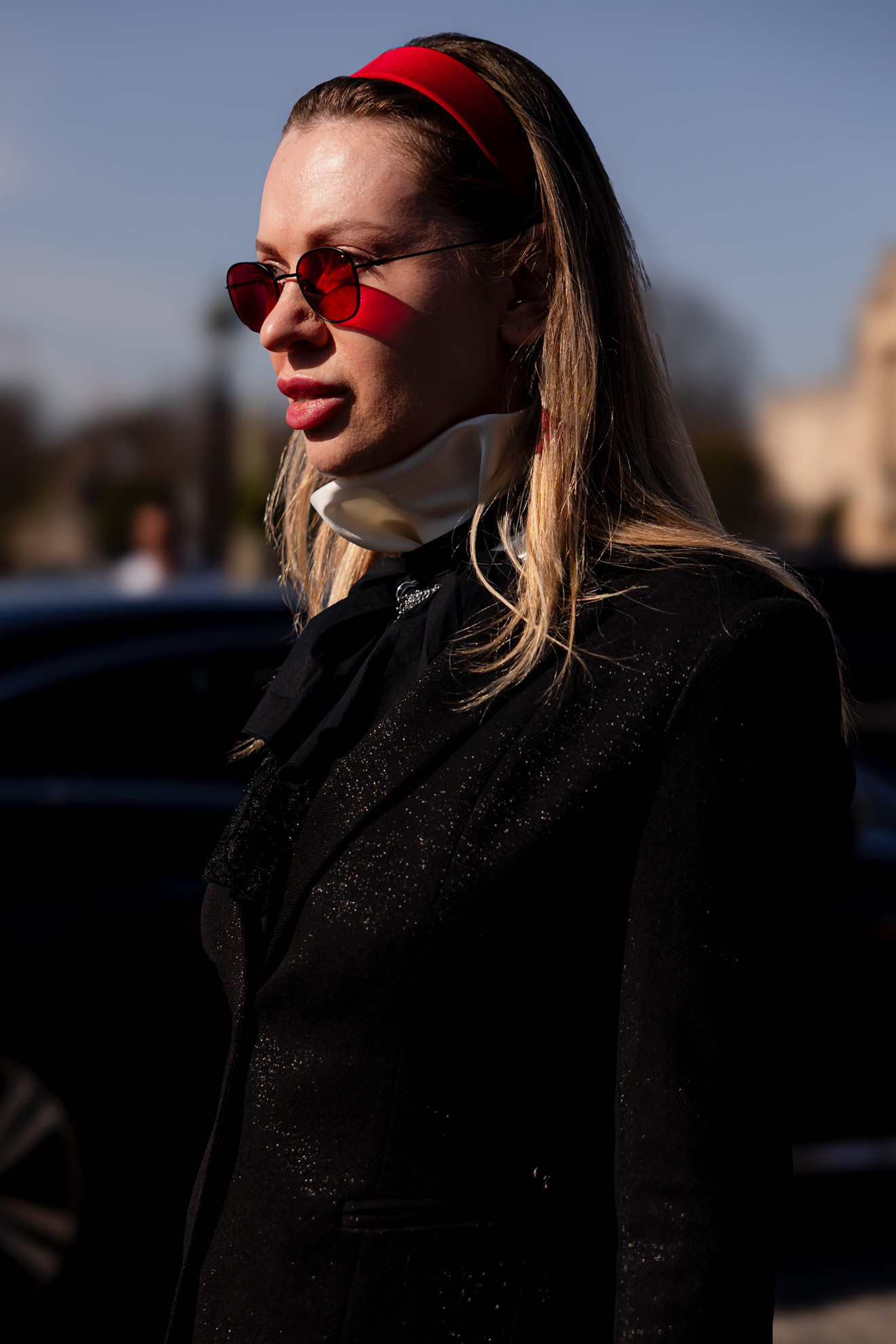 a woman with blonde hair, red headband, and red sunglasses